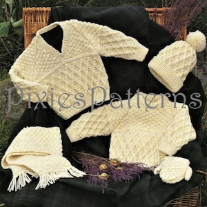 May include: A set of knitted baby clothes in a cream color, including a hat, sweater, mittens, and scarf. The set features a diamond pattern.