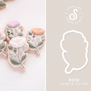 May include: A cookie cutter in the shape of a rose, with the text "ROSE cookie cutter" below it. The cutter is white and is on a light brown background. The text "SUGAR REX COOKIE STUDIO EST. 2013" is in a circle above the cutter.