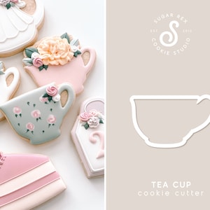 May include: A white teacup cookie cutter with a handle. The cutter is on a light brown background with the text "TEA CUP cookie cutter" below it. The text "SUGAR REX COOKIE STUDIO EST 2015" is in a circle above the cutter.