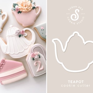 May include: Assortment of decorated sugar cookies in the shape of teapots, teacups, and cake slices. The cookies are decorated with pastel-colored icing and floral accents. A white teapot cookie cutter is also shown.
