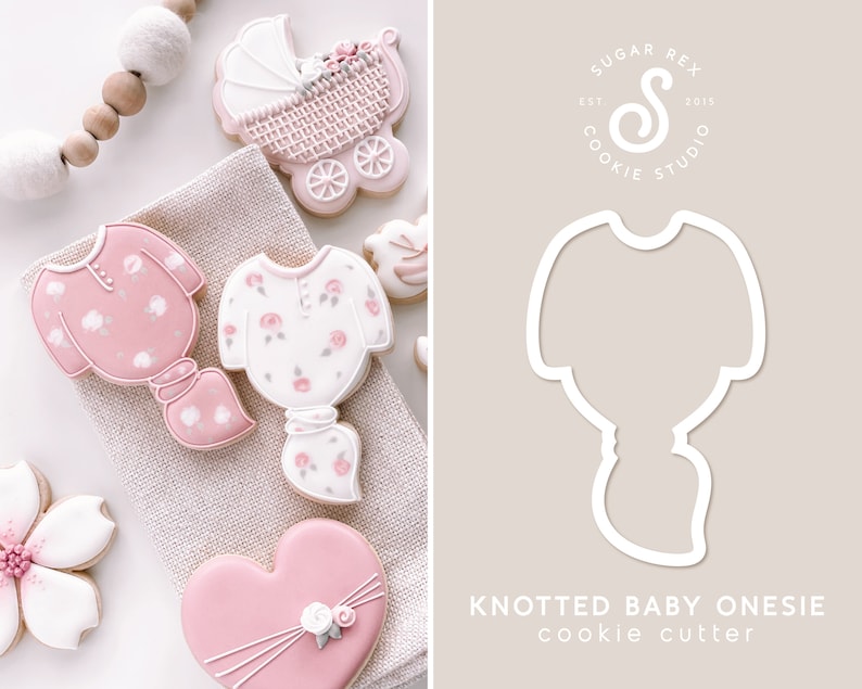 K&ouml;nnte beinhalten: Ein Set aus rosa und wei&szlig;en Baby-Strampler-Ausstechern. Die Ausstecher haben die Form eines verknoteten Stramplers, eines Kinderwagens und eines Herzens. Die Ausstecher befinden sich auf einem wei&szlig;en Hintergrund mit einem rosa und wei&szlig;en Blumendesign.
