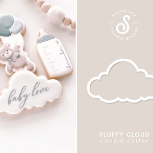 May include: White cookie cutter shaped like a fluffy cloud. The cutter is on a light brown background with the text "FLUFFY CLOUD cookie cutter" below it.