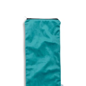 May include: Teal zippered pouch made from upcycled fabric. The pouch has a black zipper and a white label with the word "Quilted" printed on it. The pouch is made responsibly with upcycled fabric in the USA.