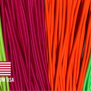 May include: Assortment of colorful elastic cords in lime green, burgundy, orange, and neon green. The cords are arranged in rows, creating a striped pattern.