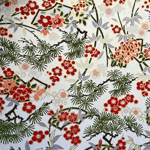 以下が含まれることがあります： 白い背景に、赤、オレンジ、白の花、緑の松葉、灰色の竹の葉が描かれた花柄の紙。 右下の黒い正方形には数字の「215」が入っています。