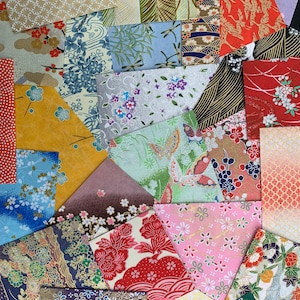 May include: Assortment of colorful patterned Japanese washi paper squares. The paper features various floral, geometric, and abstract designs in shades of pink, blue, green, red, and gold.