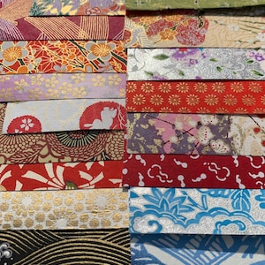 May include: A collection of colorful patterned Japanese washi paper strips. The paper features a variety of designs, including floral, geometric, and abstract patterns. The paper is perfect for scrapbooking, card making, and other craft projects.