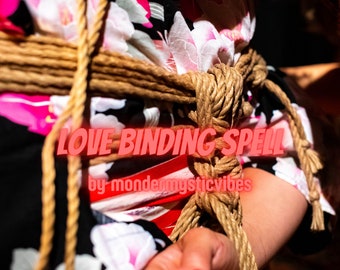 Op de afbeelding: Close-up van de torso en arm van een persoon, gebonden met dik, natuurlijk gekleurd touw. De persoon draagt een kledingstuk met bloemenpatroon. Tekstoverlay luidt "LOVE BINDING SPELL" en "by mondermysticvibes".
