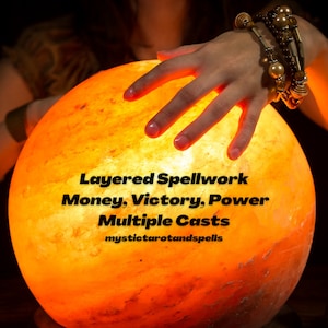 May include: A hand rests on a glowing orange crystal ball with the text "Layered Spellwork Money, Victory, Power Multiple Casts mystictarotandspells" on it.