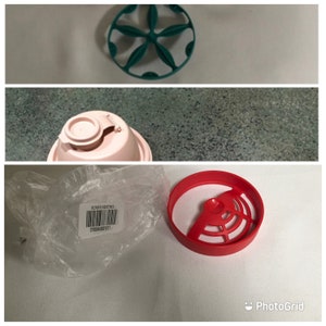 May include: A red blender insert with a green blender insert in the background. The red insert has a circular shape with a center opening and a series of spokes radiating outwards. The green insert has a similar design but is smaller and has a more rounded shape.