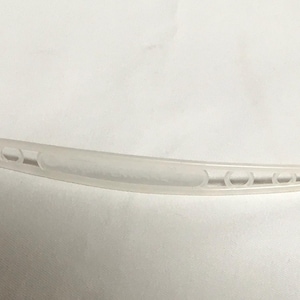 Peut inclure: Un outil en plastique blanc avec une poignée incurvée et une série de trous sur toute la longueur. L'outil est conçu pour nettoyer et enlever les débris des endroits difficiles d'accès.