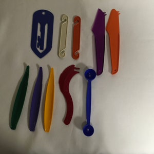 May include: A set of 10 colorful plastic kitchen tools, including a melon baller, a serrated knife, a peeler, and a few other tools.