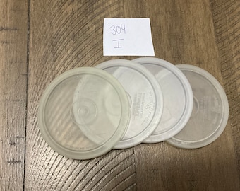 May include: Four clear plastic lids for food storage containers. The lids are stacked on top of each other.