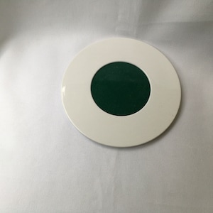 May include: A white round coaster with a green center circle.
