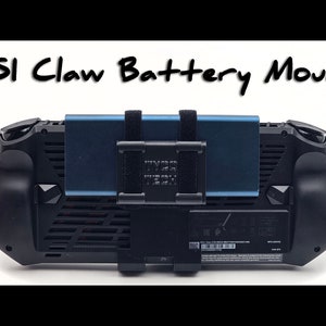 Könnte beinhalten: Ein schwarzes MSI Claw Handheld-Gaming-Gerät mit einem blauen externen Akku, der an der Rückseite befestigt ist. Der Akku hat einen schwarzen Gurt und den Text "HYPER TECH" aufgedruckt.