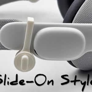 May include: Close-up of a white headset strap with a slide-on style adjustment mechanism. The strap is made of a soft, gray fabric and has a white plastic slider.