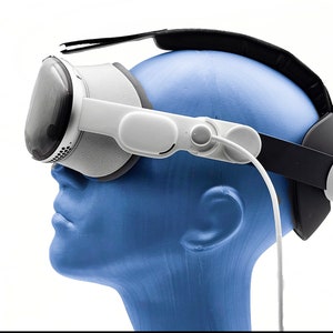 May include: A white virtual reality headset with a black headband and a white cord attached to the side. The headset is worn by a blue mannequin head.