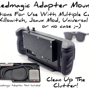 May include: Black plastic adapter mount for a gaming console. The mount is designed to fit multiple cases, including Killswitch and Jsaux Mod cases. The text "Redmagic Adapter Not Included" is printed on the bottom of the mount.