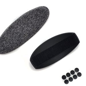 May include: An assortment of items, including a gray, oval-shaped pad, a black, curved pad with a velcro strip, and several small, black circular pads. All items are set against a white background.