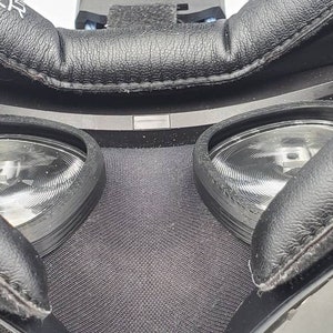 May include: Close-up of the inside of a virtual reality headset, showing two black lenses with a textured surface.