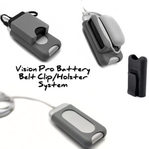 May include: Multiple views of a grey Vision Pro Battery Belt Clip/Holster System are shown. The system includes a grey battery case with a silver accent, a black belt clip, and a cable. The text "Vision Pro Battery Belt Clip/Holster System" is written in black.