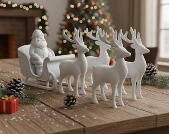 May include: A white ceramic Santa Claus in a sleigh pulled by four white reindeer. The Christmas decoration is on a wooden table with pine cones, small wrapped gifts, and evergreen branches. A Christmas tree is in the background.