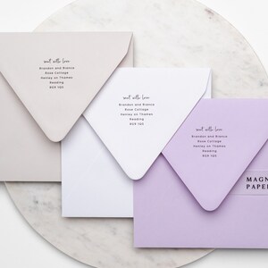 Puede incluir: Tres sobres en colores neutros: beige, blanco y lavanda. Cada sobre est&aacute; dirigido con el texto "sent with love" y un nombre y una direcci&oacute;n. Una banda transparente con el texto "MAGNA PAPERS" envuelve el sobre lavanda.