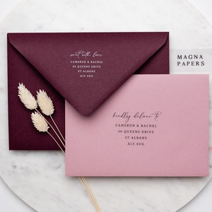May include: Two envelopes, one burgundy and one pink, with the text "sent with love" and "kindly deliver to" on them. The envelopes are addressed to Cameron & Rachel, 30 Queens Drive, St Albans, AL5 4UG. A clear sticker with the text "MAGNA PAPERS" is on the pink envelope.