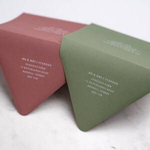 May include: Two envelopes, one in a muted red color and the other in a muted green color, with the same address printed in white on each. The address reads: "MR & MRS J STANDEN, SUNFIELD FARM, 11 HATCHLANDS ROAD, REDHILL, SURREY, RHS 7UB".
