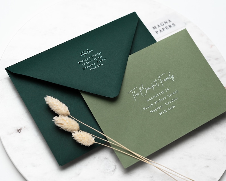 May include: Two envelopes, one dark green and one light green, with white text. The dark green envelope has the text "with love" and an address. The light green envelope has the text "The Beaufort Family" and an address.