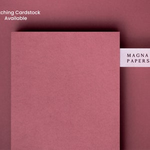 May include: A close-up of a deep pink cardstock sample with a white label that reads "MAGNA PAPERS".