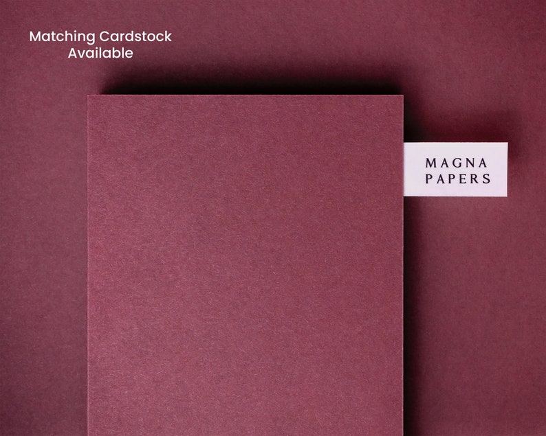 May include: A close-up of a deep burgundy cardstock sample with a white label that reads "MAGNA PAPERS".