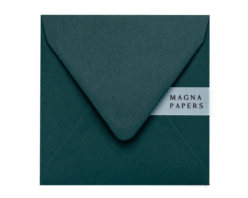 May include: A dark green envelope with a white label that says "MAGNA PAPERS".