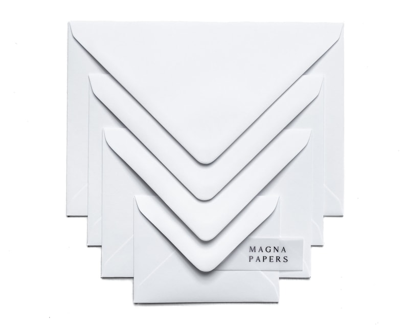 May include: A set of five white envelopes of different sizes, with the brand name "MAGNA PAPERS" printed on a label on the smallest envelope.