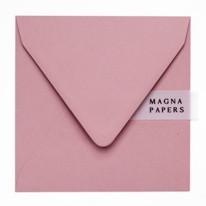 May include: A dusty rose envelope with a white label that says "MAGNA PAPERS".