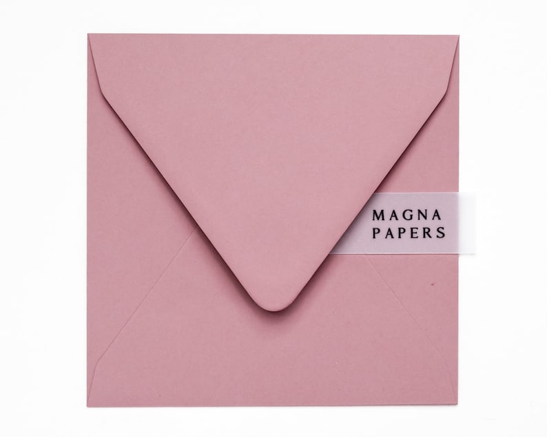 May include: A dusty rose envelope with a white label that says "MAGNA PAPERS".