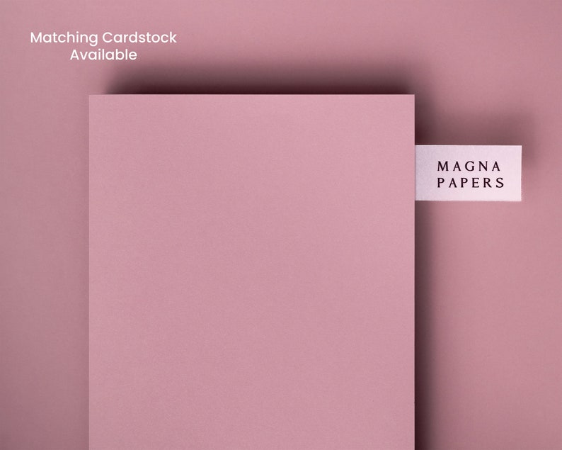 May include: A close-up of a pale pink cardstock sheet with a white label that reads "MAGNA PAPERS" on it.