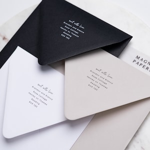 May include: Three white envelopes with black text on them. The text reads "sent with love" followed by the address "Brandon and Bianca, Rose Cottage, Henley on Thames, Reading, RG9 105". The envelopes are stacked on top of each other. The top envelope is a light beige colour. The bottom envelope is white. The middle envelope is black. The envelopes are on a white marble surface. The text "MAGNA PAPERS" is visible in the top right corner of the image.