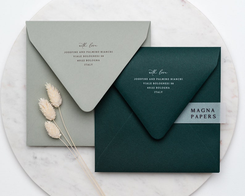 May include: Two envelopes, one green and one gray, with the text "with love" and an address printed on each. The green envelope has a white label with the text "MAGNA PAPERS" on it.