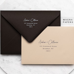 May include: Two envelopes with the names "Andrew + Catherine" and the address "335 Greenwich Street, Brooklyn, NY 10013" printed on them. The envelopes are on a marble surface. A small white label with the text "MAGNA PAPERS" is visible in the top right corner of the image.