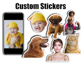 May include: A set of custom stickers featuring a variety of images, including a baby in a yellow hat, a golden retriever, a brown and white puppy, a woman with long dark hair, a cat, and a man and child. The stickers are printed on white paper with a glossy finish.