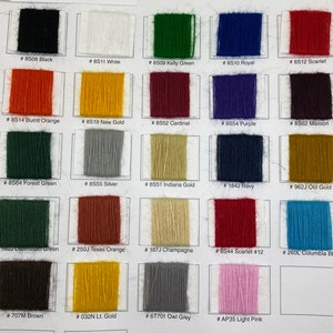 May include: A color chart featuring twenty-four rectangular swatches of embroidery thread arranged in a grid. Each swatch is labeled with a specific code and color name, including Black, White, Kelly Green, Royal, Scarlet, Burnt Orange, New Gold, Cardinal, Purple, Maroon, Forest Green, Silver, Indiana Gold, Navy, Old Gold, Dartmouth Green, Texas Orange, Champagne, Scarlet #12, Columbia Blue, Brown, Lt. Gold, Owl Grey, and Light Pink.