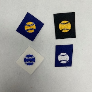 以下が含まれることがあります： 野球のデザインが施されたアイロン接着式の刺繍パッチが4つ。パッチは、青、黒、白、紺の異なる色の生地の背景になっています。野球は、黄色、白、青の糸で刺繍されています。