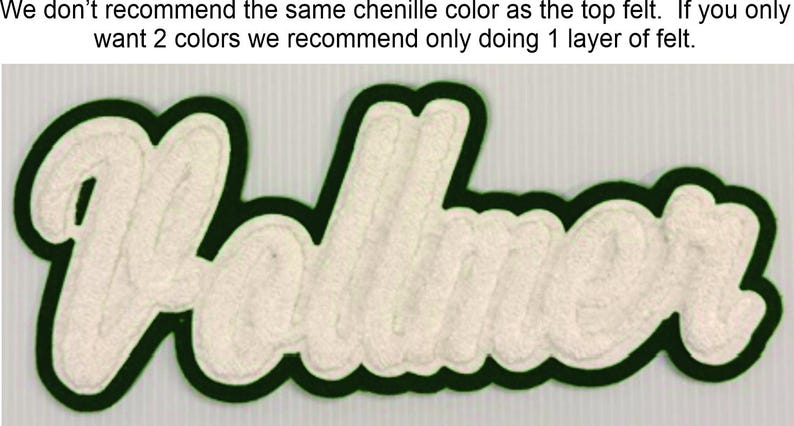 May include: A custom chenille patch featuring the name Vollmer in white script lettering. The patch has a dark green felt border and includes the text: We don't recommend the same chenille color as the top felt. If you only want 2 colors we recommend only doing 1 layer of felt.