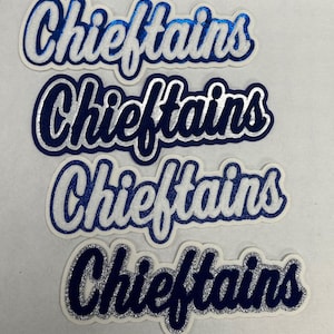 May include: Four die-cut iron-on patches featuring the word Chieftains in a cursive script font. The patches display various color combinations of blue, white, and silver glitter textures with layered outlines and a white border.