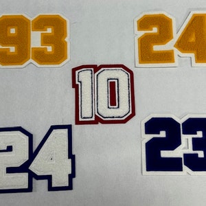 以下が含まれることがあります： 異なる番号のアイロン接着パッチが5つあります。番号は93、24、10、24、23です。パッチは黄色、白、赤、青など、さまざまな色があります。