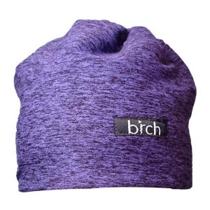 May include: A purple beanie hat with a textured fabric. The hat has a small black rectangular tag with the white word "birch" printed on it. The hat is made of a soft, stretchy material.
