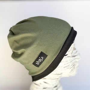 May include: A green beanie with a black fold-over brim and a small black label with the text "birch" in white.