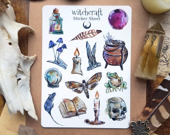 Puede incluir: Una hoja de pegatinas con temática de brujería que presenta ilustraciones de un caldero, una rana, una polilla, un libro, una vela, una calavera, una botella, setas, una bola de cristal y una pluma. La hoja de pegatinas se titula "Witchcraft Sticker Sheet".