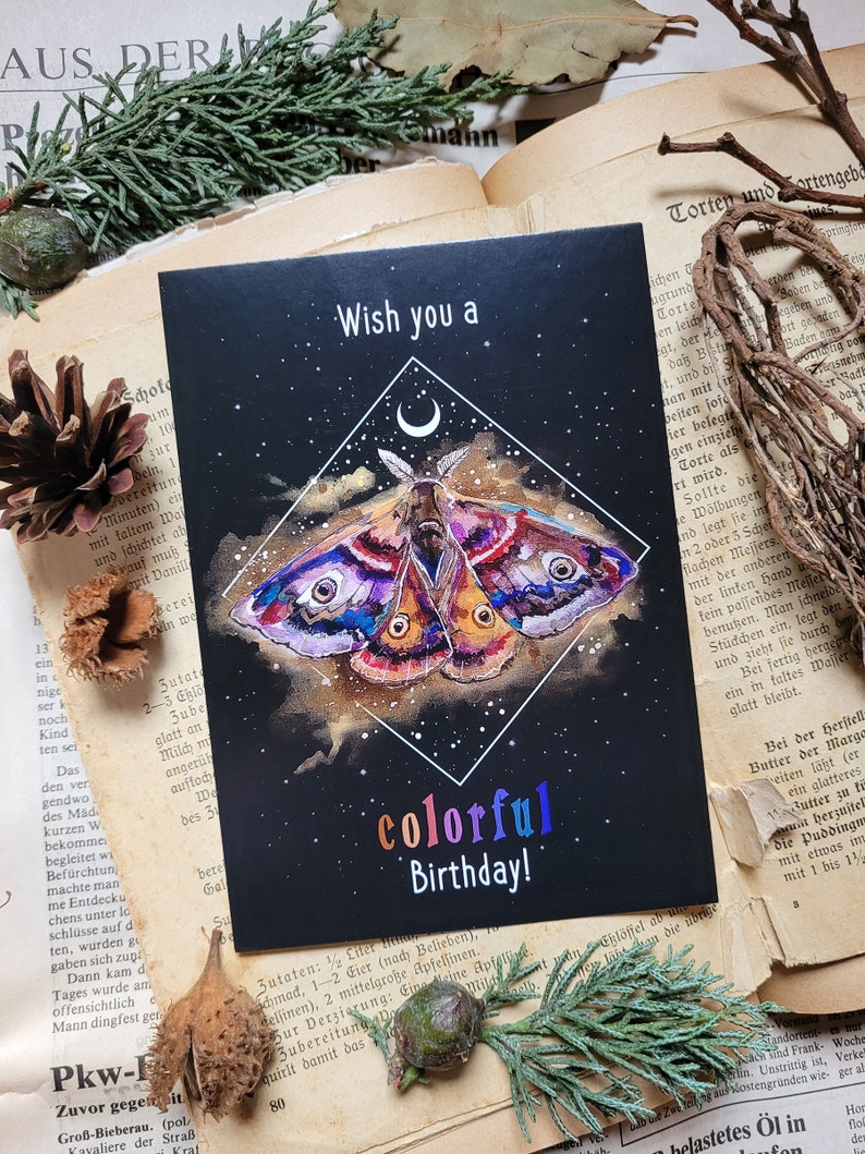 May include: A black card with a colorful butterfly illustration and the text "Wish you a colorful Birthday!" on a black background with a crescent moon and stars.